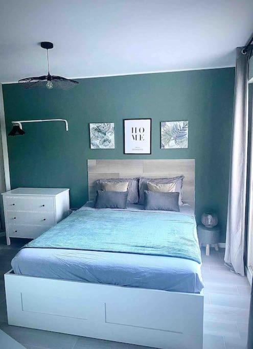 um quarto com uma cama e uma parede verde em Studio Magali 2 em Tarascon