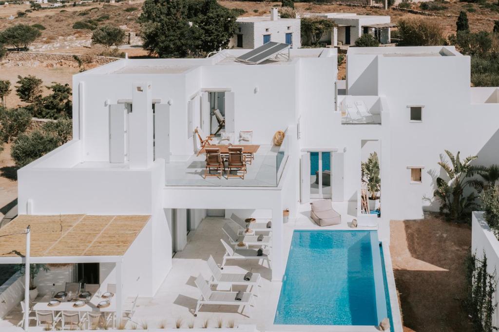 an aerial view of a white house with a swimming pool at Sunsenses villa Ariadne in Piso Livadi