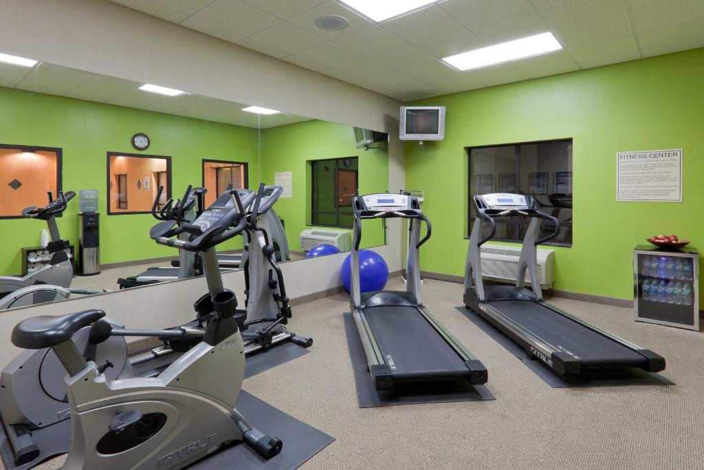 einen Fitnessraum mit Laufbändern in einem Raum mit grünen Wänden in der Unterkunft Holiday Inn Carbondale - Conference Center, an IHG Hotel in Carbondale