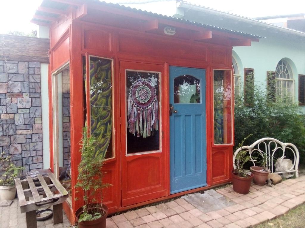 una puerta delantera roja y azul de una casa en BohippienJBAY, en Jeffreys Bay