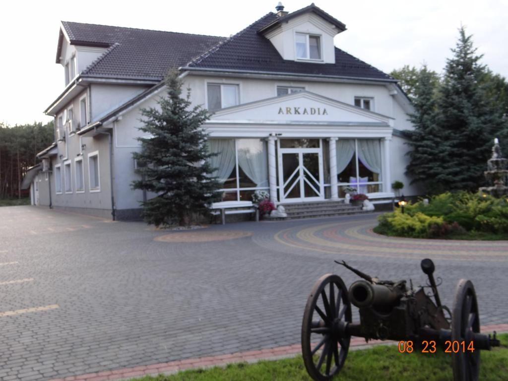 an old car parked in front of a building at "Arkadia" in Ostrołęka