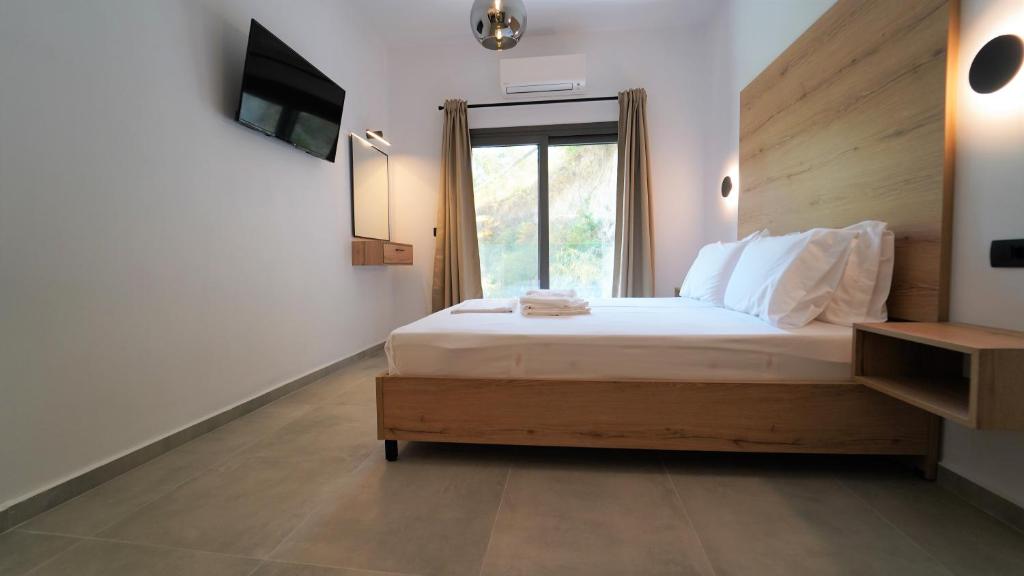 Un dormitorio con una cama grande y una ventana en Enjoy Parga Appartments, en Parga
