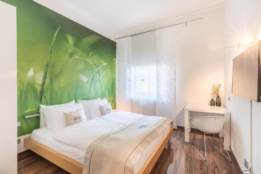 a bedroom with a bed and a green wall at Hotel Freiraum in Mönchengladbach