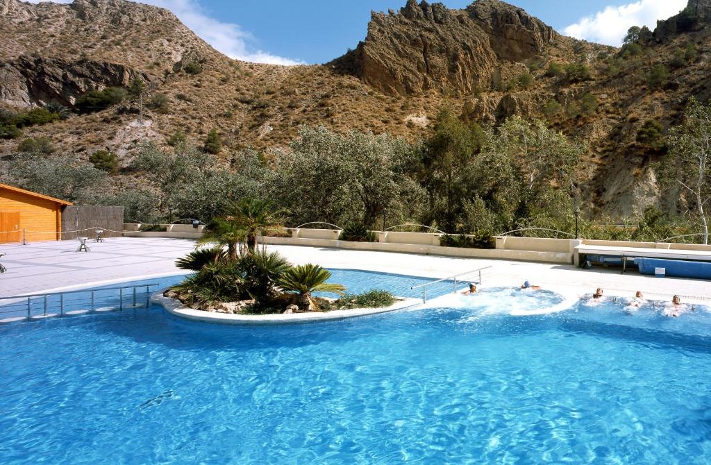 a swimming pool with a mountain in the background at Balneario de Archena - Hotel Levante in Archena