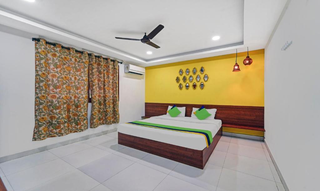 1 dormitorio con cama y pared amarilla en Treebo Trend Signature Grande en Pondicherry