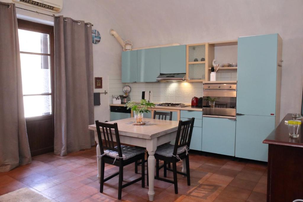 una cucina con armadi blu, tavolo e sedie di Molina apartment 213 a Pugnano