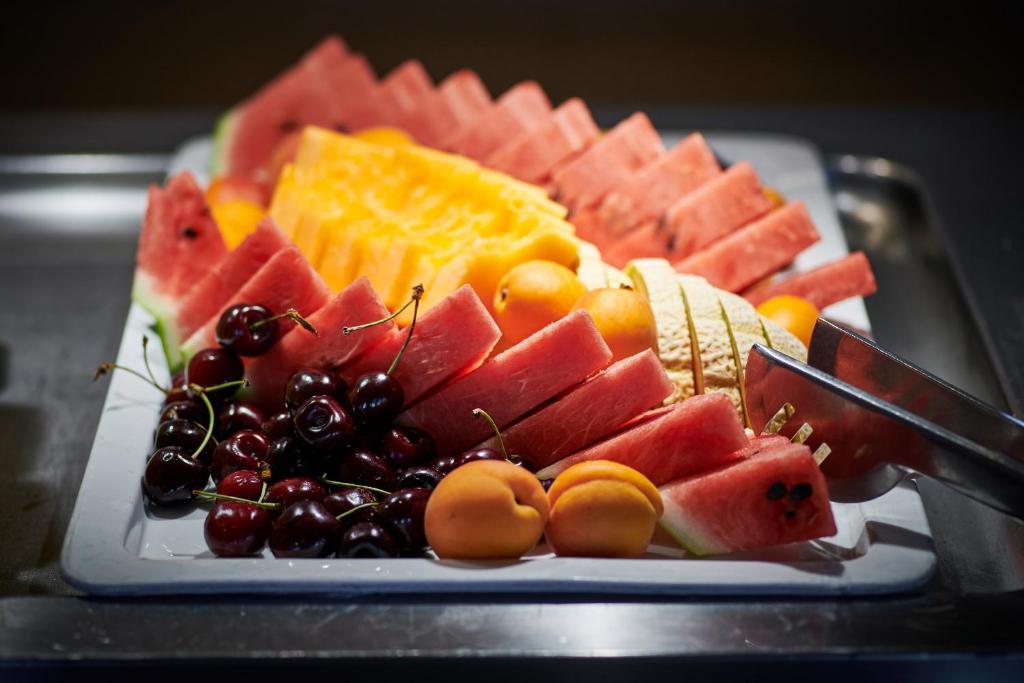 a platter of fruit on a plate with a knife at Hotel Adria in Dubrovnik