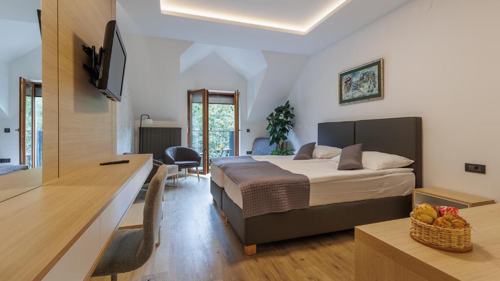1 dormitorio con 1 cama y escritorio con TV en Gostilna Müller, en Črnomelj