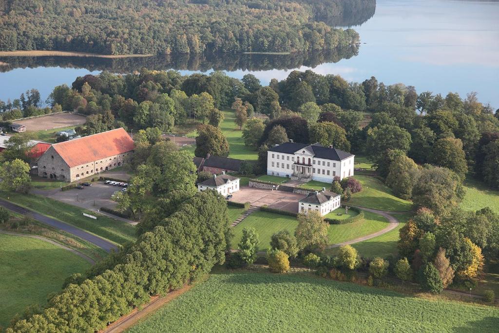 an aerial view of a large white house on a lake at Nääs Slott in Floda