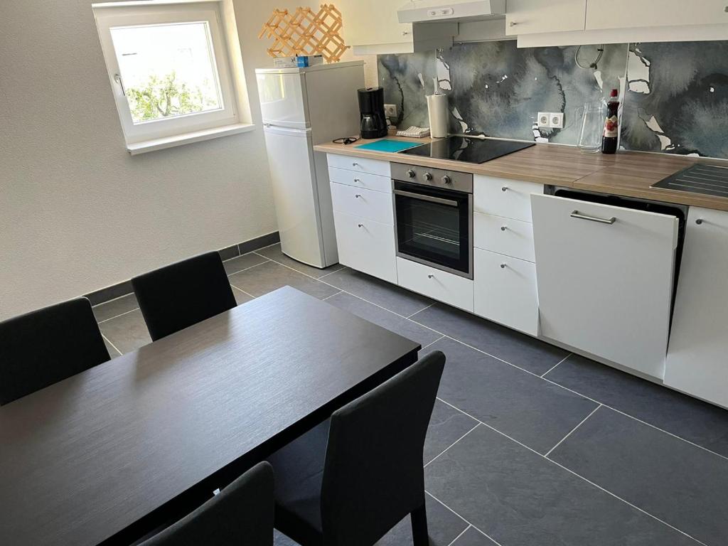 a kitchen with a table and a kitchen with white appliances at Apartment 2 in Lendorf