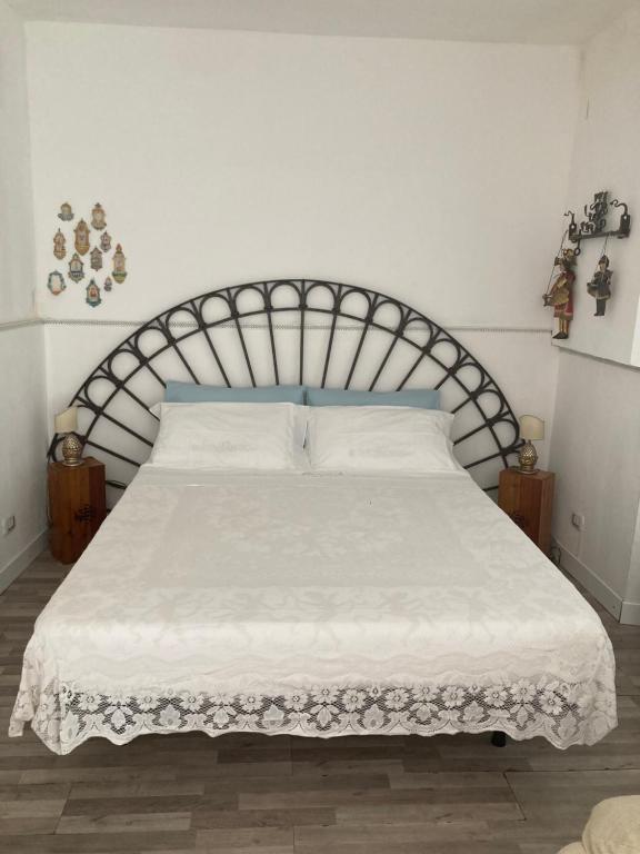 a bedroom with a white bed with a blue headboard at casa Tuccari Castiglione di Sicilia in Castiglione di Sicilia