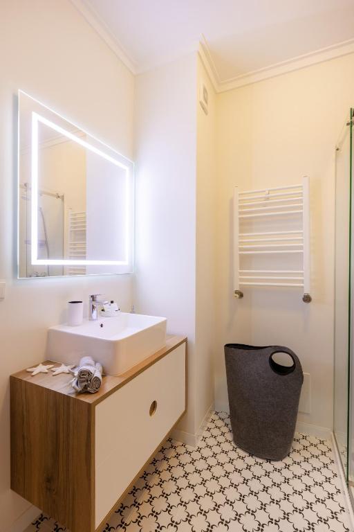a bathroom with a sink and a mirror at São Félix Seaside Oasis in São Félix da Marinha