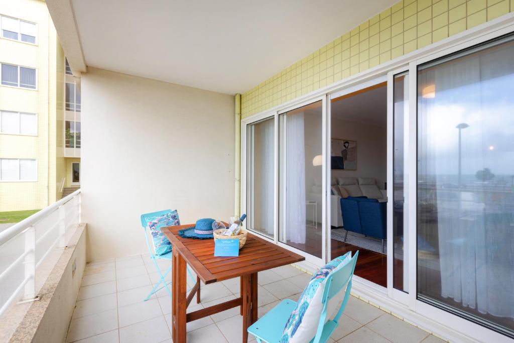 a balcony with a wooden table and two chairs at São Félix Seaside Oasis in São Félix da Marinha