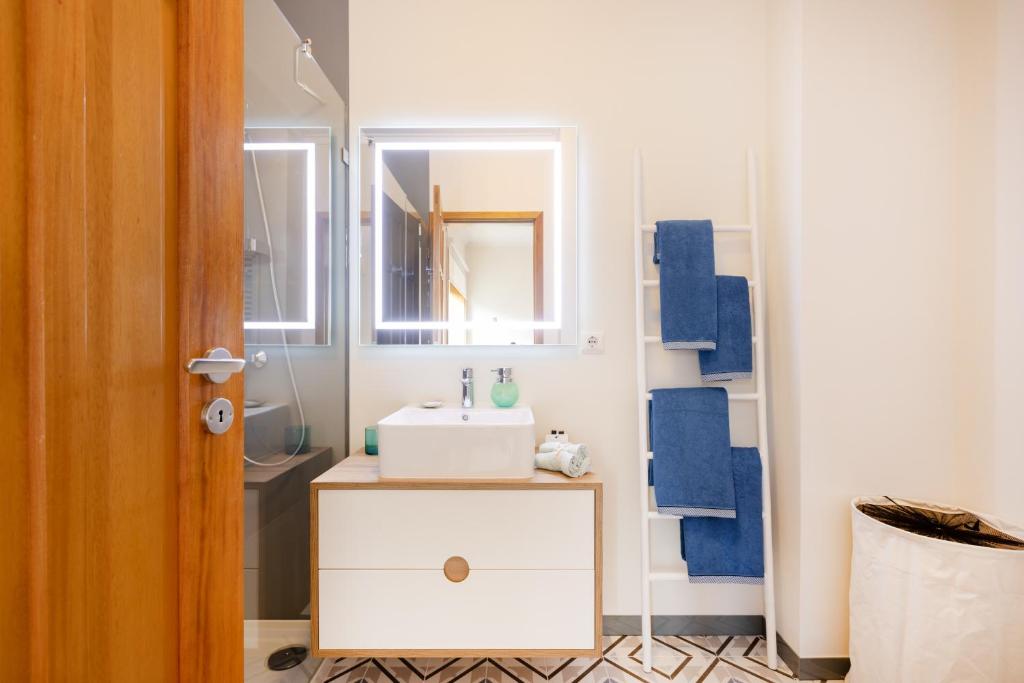 a bathroom with a sink and a mirror at São Félix Seaside Oasis in São Félix da Marinha