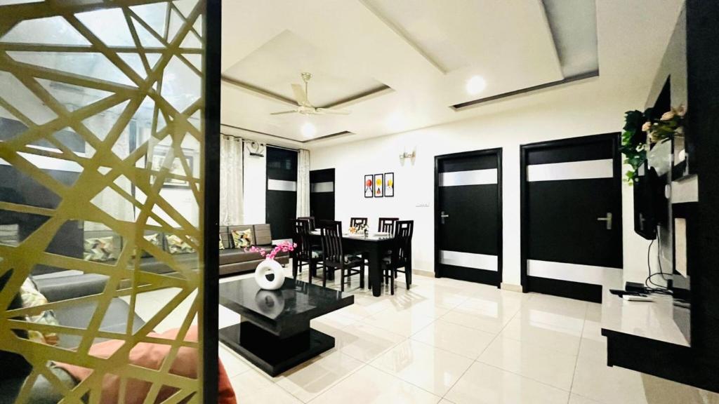 a living room with a table and a dining room at Olive Service Apartments - Vaishali Nagar in Jaipur