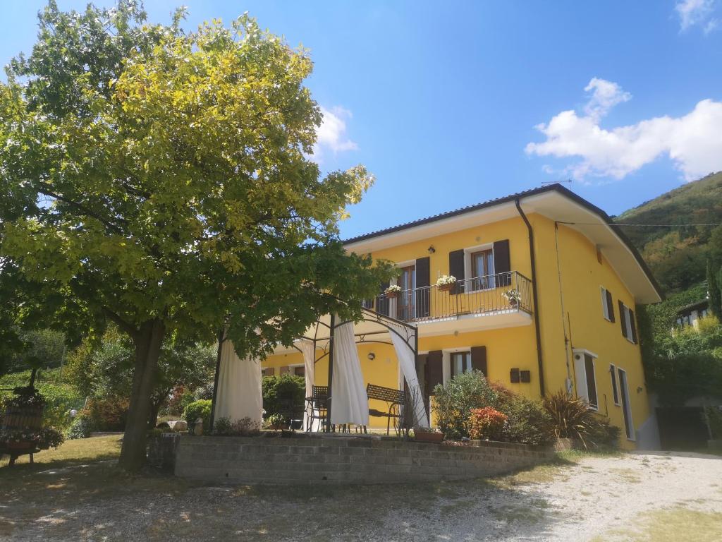 a yellow house with umbrellas in front of it at ABC Rooms in Valdobbiadene