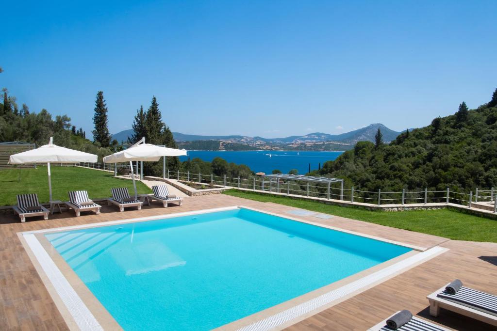 a swimming pool with chairs and a view of the water at Aspasia's mansion in Lygia