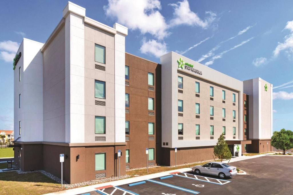 Extended Stay America Premier Suites - Augusta في أوغوستا: مبنى مكتب مع سيارة متوقفة في موقف للسيارات