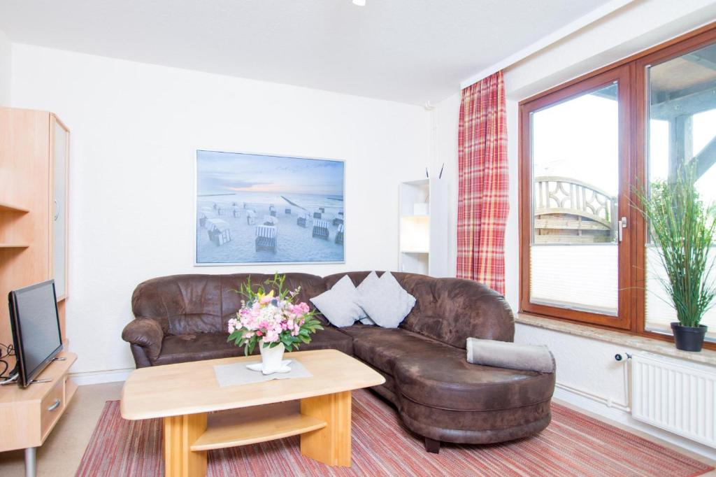 a living room with a brown leather couch and a table at Ferienhof Kluvetasch Appartement Nr 3 - Seestern in Rettin