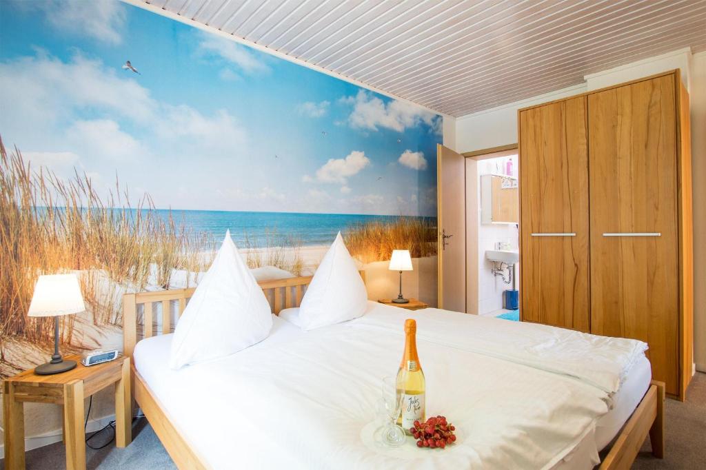 a bedroom with a bed with a bottle of wine at Ferienhof Kluvetasch Appartement Nr 4 Ostseeblick in Rettin