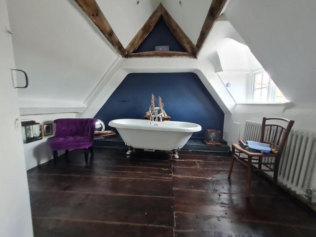 a bathroom with a large white tub in a attic at The Old Church House top floor in private house central Frome in Frome