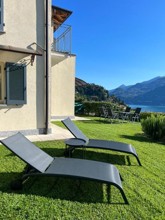 two lounge chairs on the grass next to a building at Lago e Giardino apartment in Bellagio