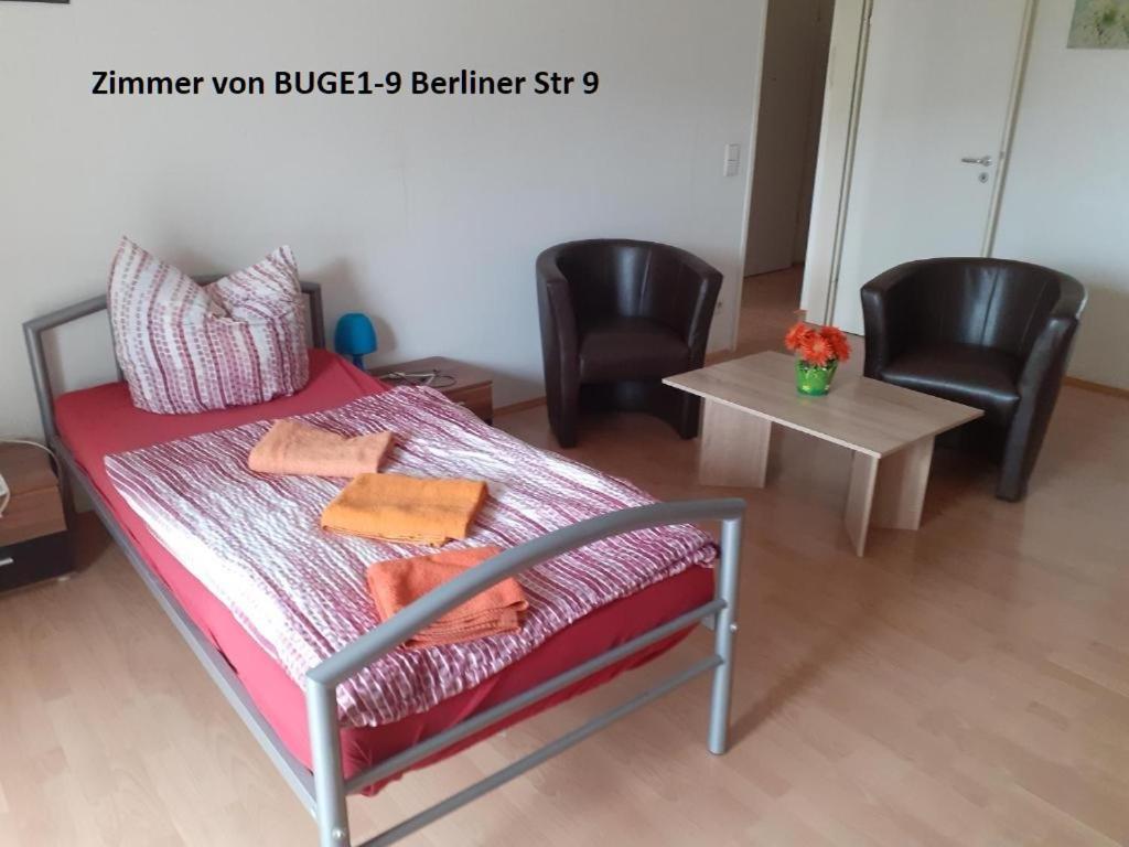 um quarto com uma cama com 2 cadeiras e uma mesa em Apartment Berliner Strasse em Leipzig