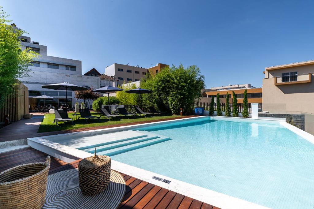 a swimming pool on a deck next to a building at 4615 Hotel in Felgueiras