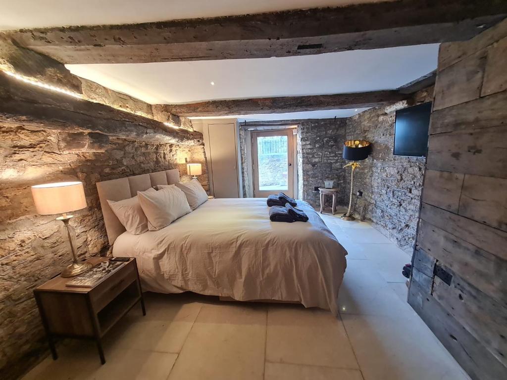 een slaapkamer met een groot bed en een stenen muur bij The Undercoft luxury private studio at The Old Church House central Frome in Frome