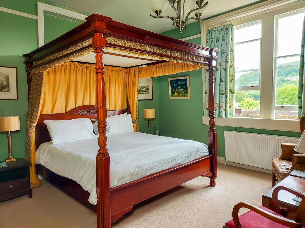 バースにあるGrosvenor Villaの緑の壁のベッドルームで、天蓋付きベッドが備わります。