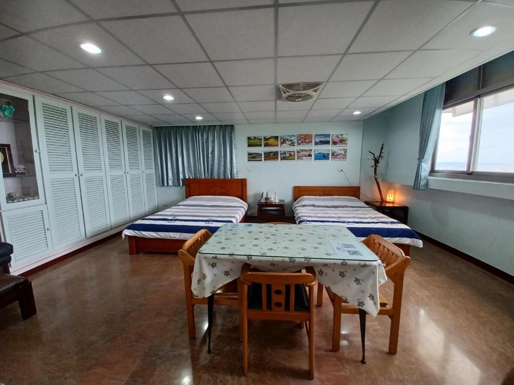 a room with two beds and a table and chairs at Smile house Homestay in Taiping