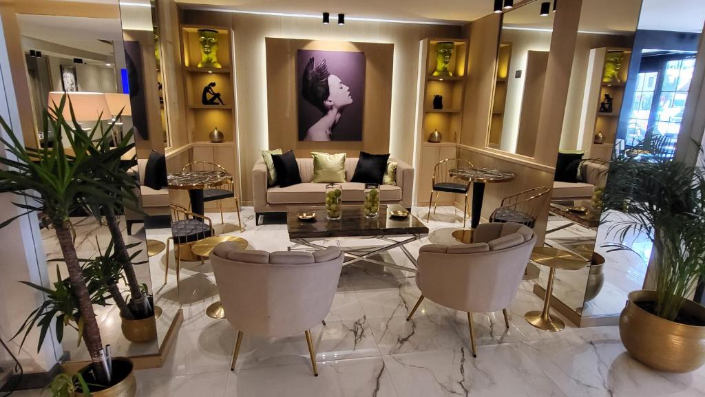vestíbulo con sofá, sillas y plantas en Hotel Le Fouquet's, en Cannes