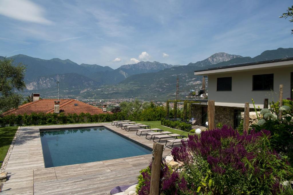 un patio trasero con piscina y una casa en Gazzi Apartments 'Panoramic & Relaxing', en Arco