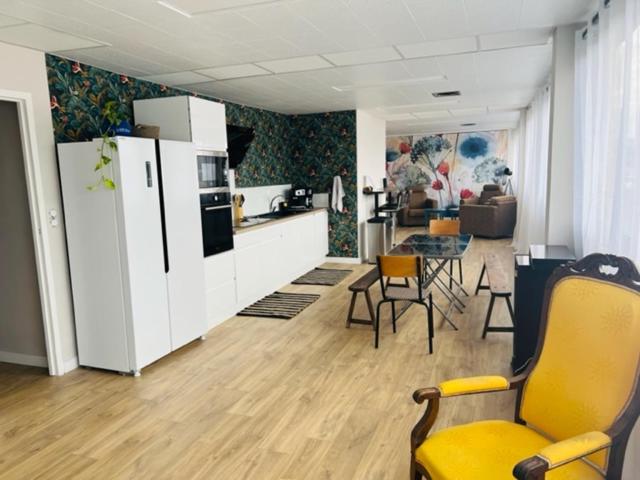 Il comprend une cuisine et un salon avec une chaise jaune. dans l'établissement LORIENT EXPRESS, à Lorient