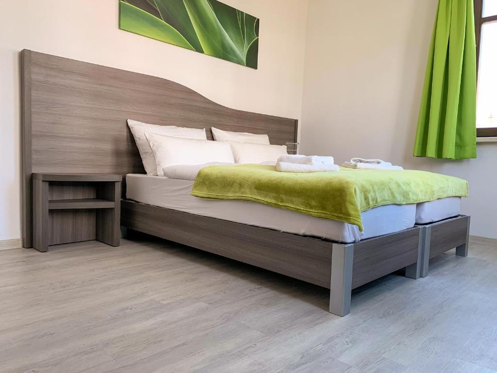 um quarto com uma cama com um cobertor verde em Rhöner Ferienwohnung em Stadtlengsfeld