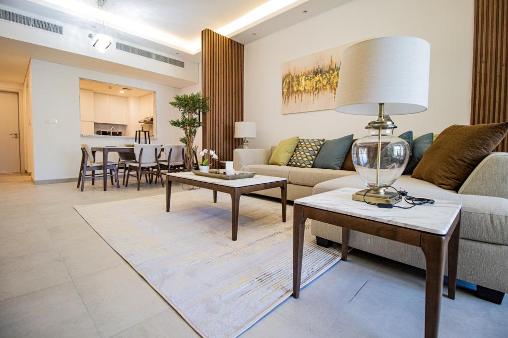 Stunning, Upgraded 2-BR Apartment in Lamtara 2 MJL Burj Al Arab View في دبي: غرفة معيشة مع أريكة وطاولة