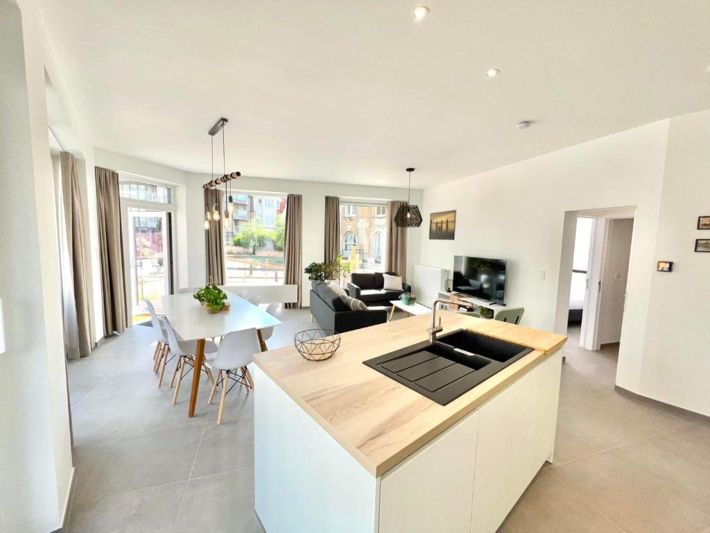 a kitchen and a living room with a table at Family apartment on the ground floor with terrace - Panne A Côte in De Panne