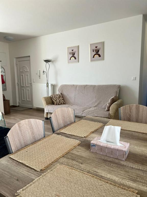 salon z kanapą, stołami i krzesłami w obiekcie Edmond Apartment w Hévízie