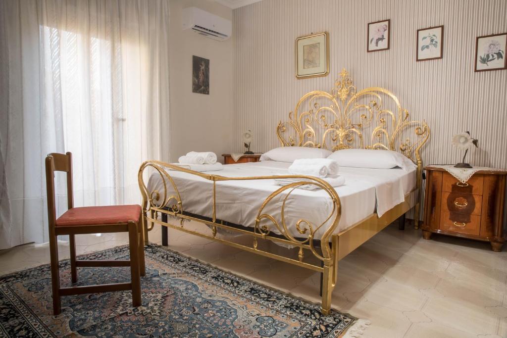 Un dormitorio con una cama dorada y una silla en B&B Chiaro di Luna en Corleone