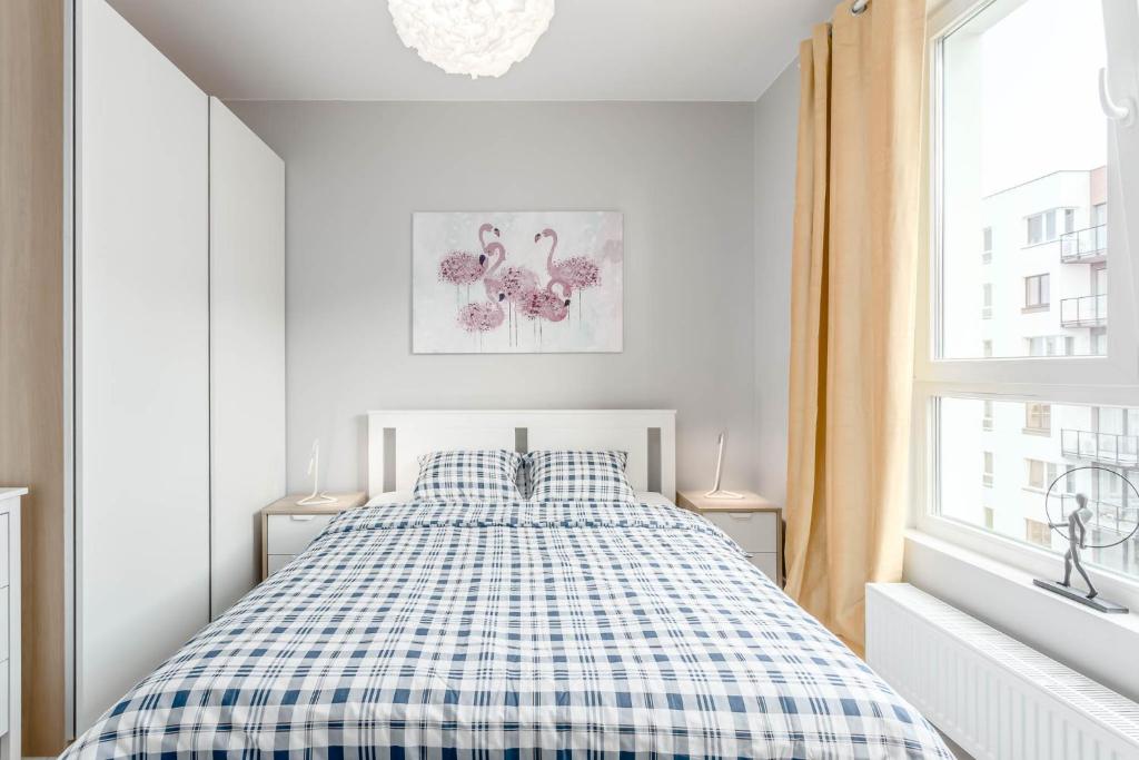 sypialnia z łóżkiem z kocem szachowym w obiekcie Chill Apartments Ursus w Warszawie