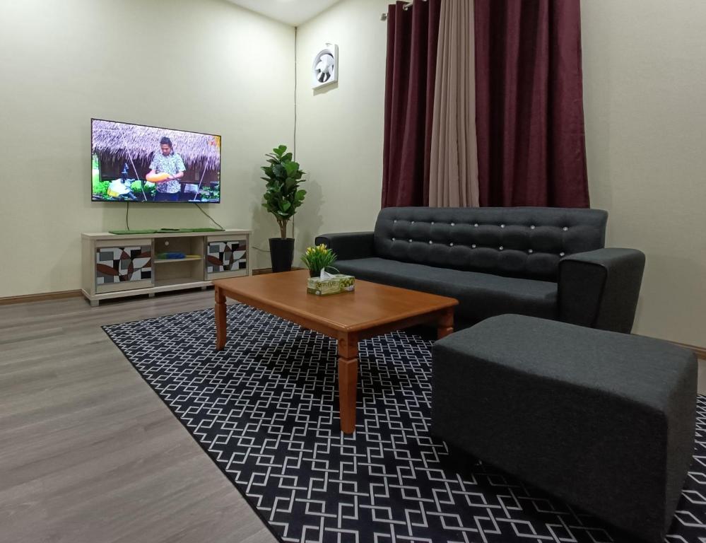 een woonkamer met een bank en een salontafel bij Fadli HOMESTAY in Kota Bharu