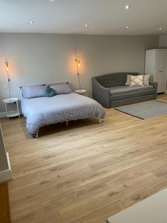 1 dormitorio con 1 cama y 1 sofá en The Woodside Snug, Eastwell, Vale of Belvoir 