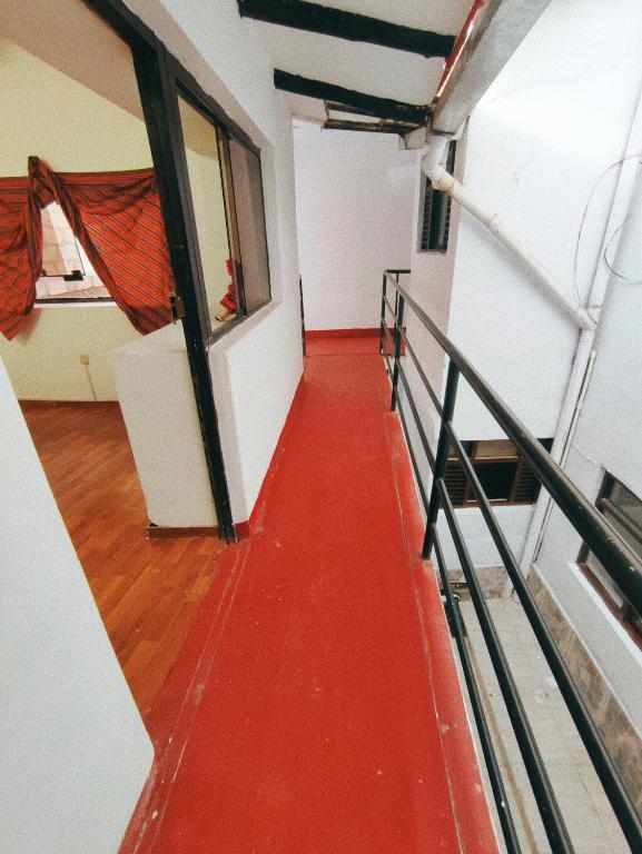 a hallway with a red floor in a building at ENEDE HOSTEL in Cusco