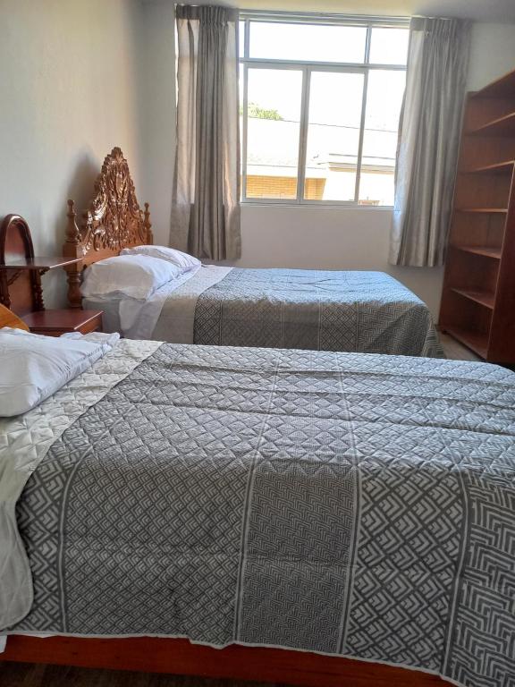 a hotel room with two beds and a window at Hospedaje Margarita in La Merced