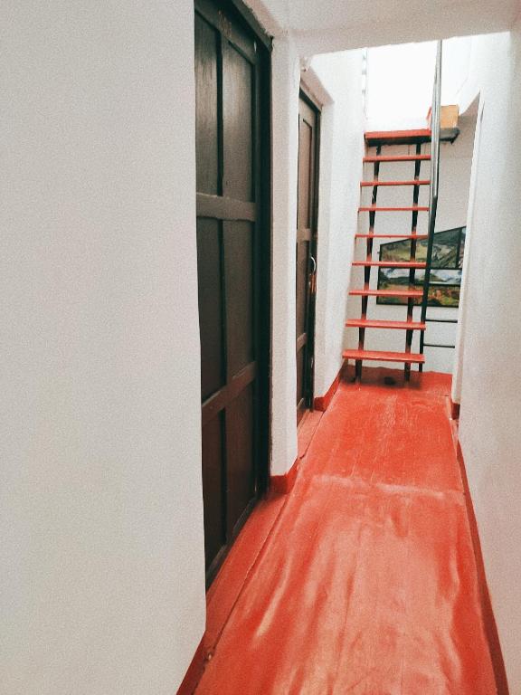 an empty hallway with an open door and a staircase at ENEDE HOSTEL in Cusco