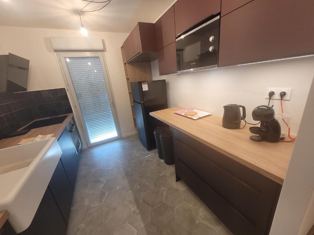 cocina con encimera y nevera en Bel appartement contemporain proche des commodités en Toulouse