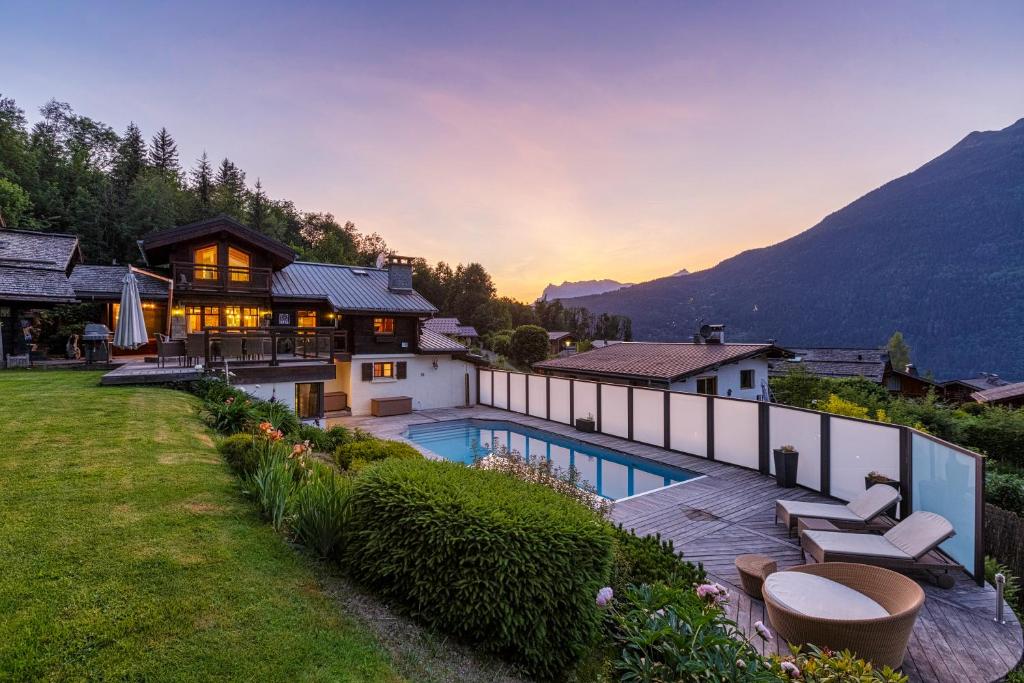 a house with a swimming pool and a mountain at Chalet Galadhrim Chamonix Mont Blanc Valley in Les Houches