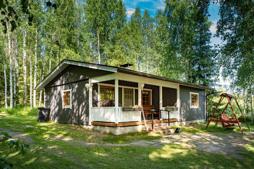 a small house in the woods with a swing at Koivuranta in Räätäniemi
