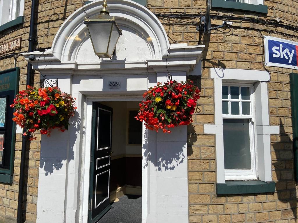 a building with two flower baskets over a door at Ivy Green inn in Huddersfield