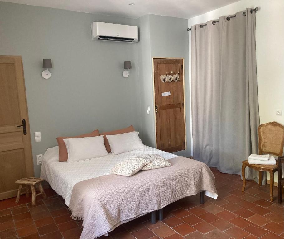 a bedroom with a bed with white sheets and a heater at Casa Cessenon in Cessenon